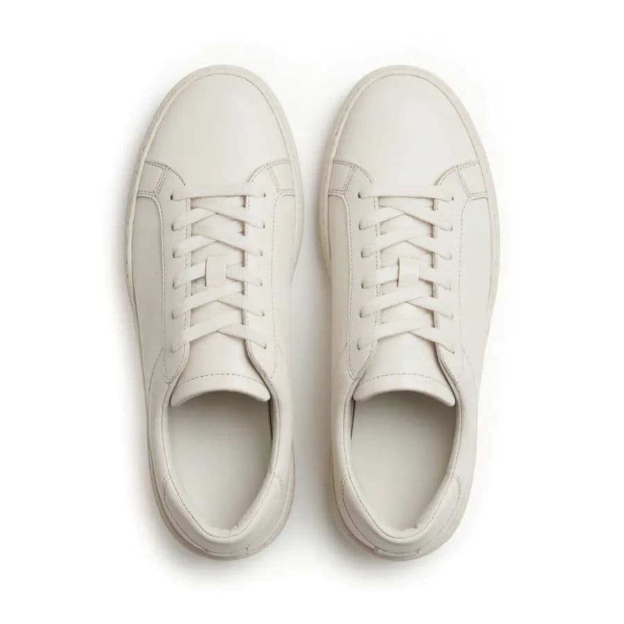 White leather sneakers on a pure white background, top-down view