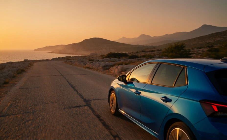 Blue hatchback driving on a coastal road