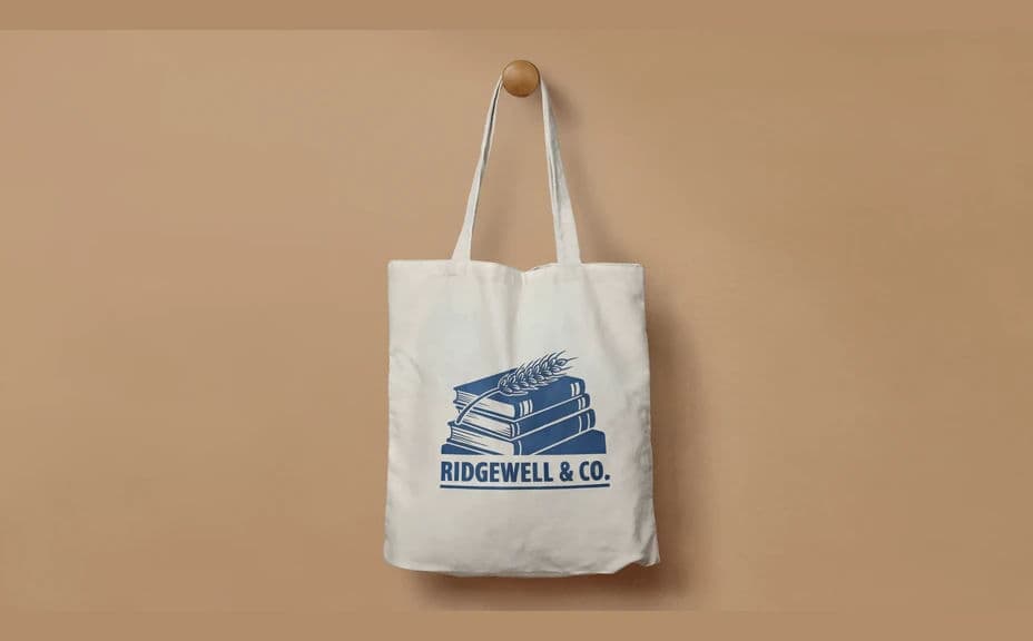 The same tote bag design shown hanging from a peg against a warm wall