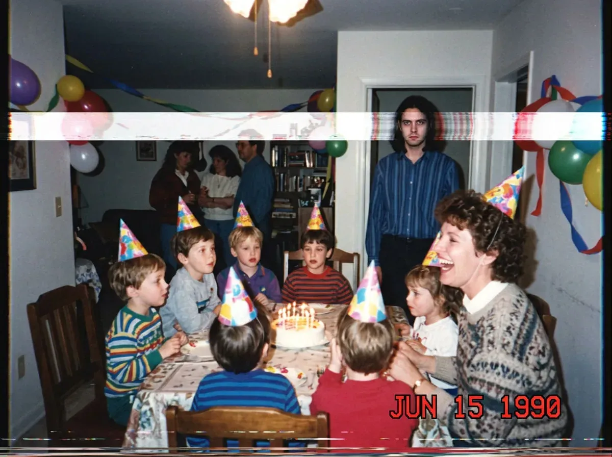 VHS freeze-frame of a family birthday party where one guest at the back has a face smeared by tape distortion, generated with Nano Banana 2