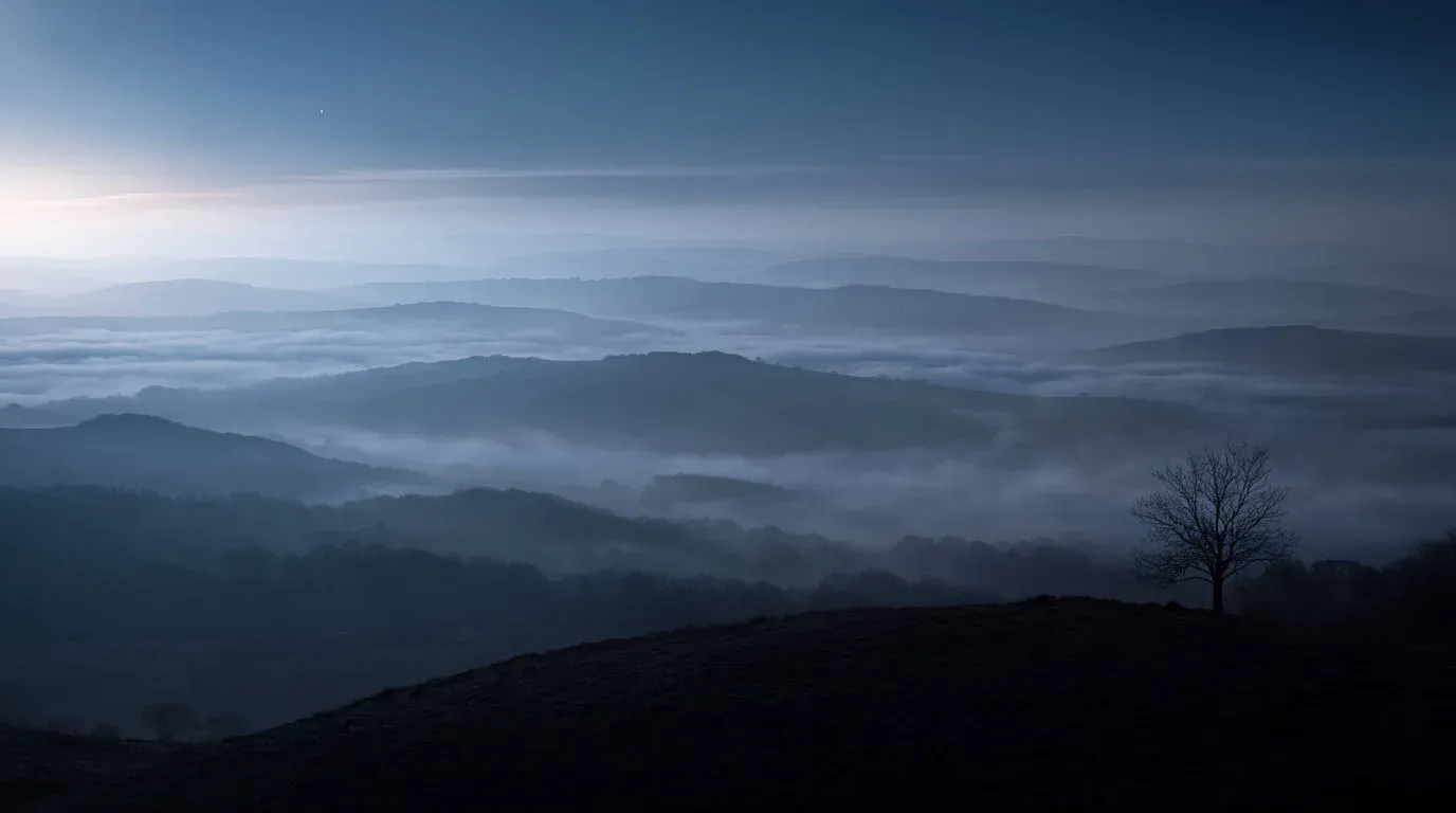 Layers of rolling hills with fog pooling in the valleys at blue hour, generated with Krea 2 Large