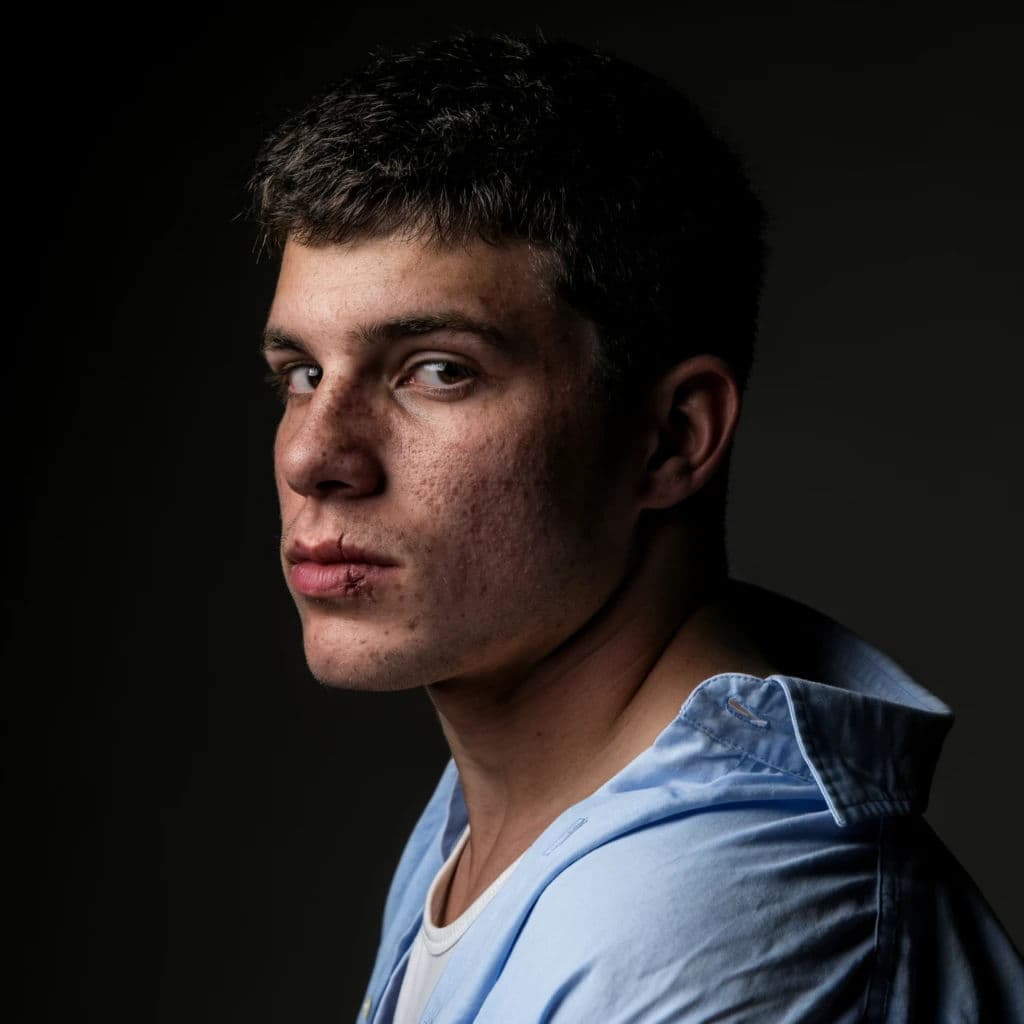Square studio portrait of a young man face turned so one side is lit and the other falls into shadow, generated with Krea 2 Large