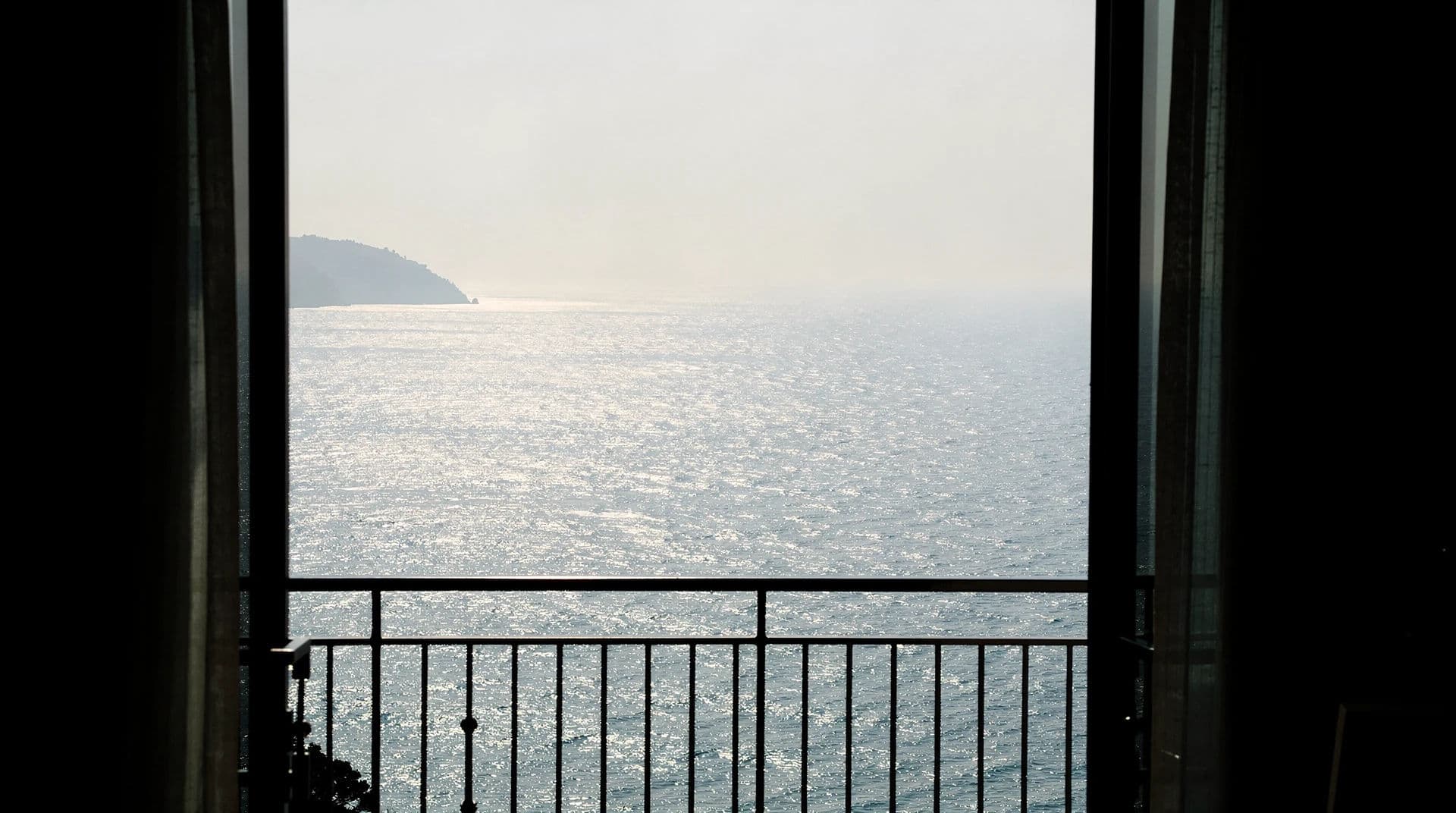 Listing photograph exposed for a sea view with the balcony interior falling to silhouette, generated with Flux 2 Pro