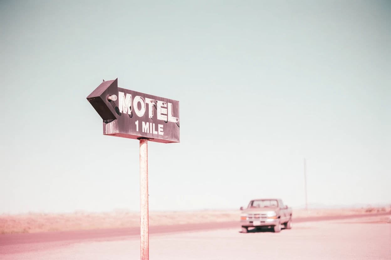 Sun-bleached low contrast photograph of a roadside motel sign, generated with Krea